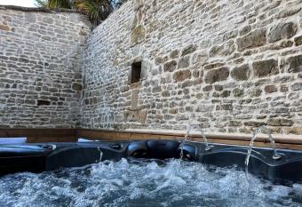 Maison en pierre avec jacuzzi has rooms with a private hot tub